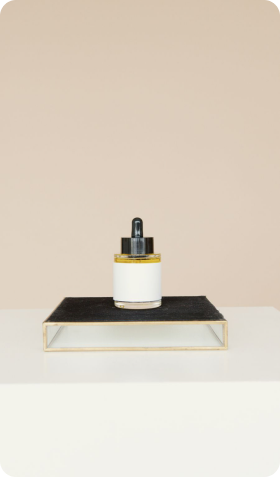 Daily Glow Serum bottle on a black stand